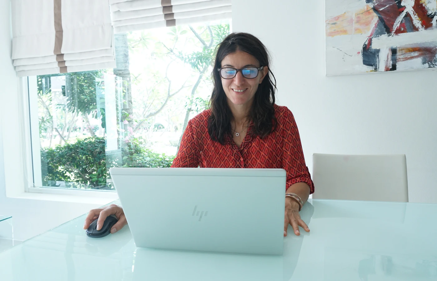 Freelancer working on a laptop at a desk by the window